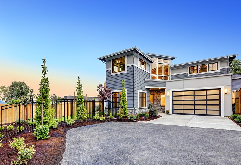 Excellent curb appeal of a Modern craftsman style home accented by landscaping, gray siding, large windows and Frosted Glass Garage Door. Northwest, USA
