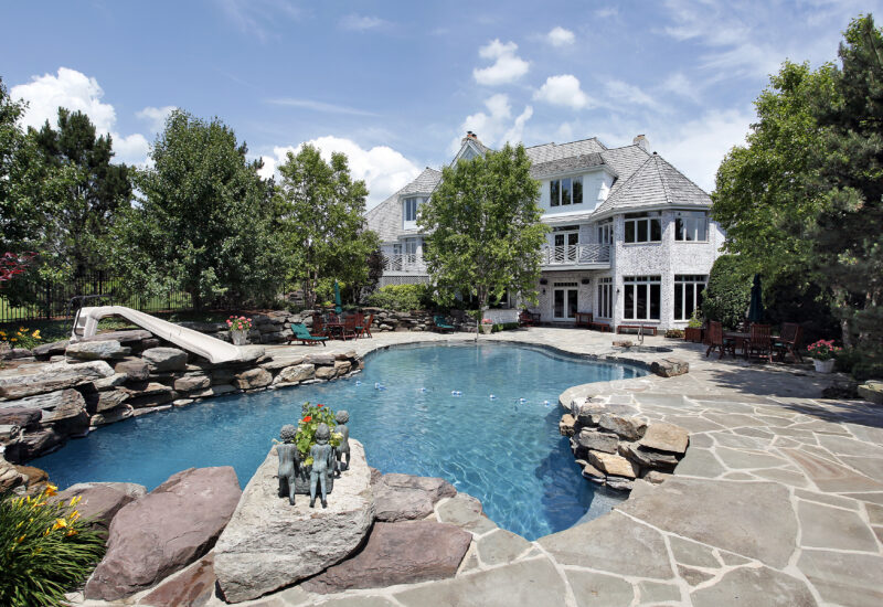 Rear view of luxury home with swimming pool